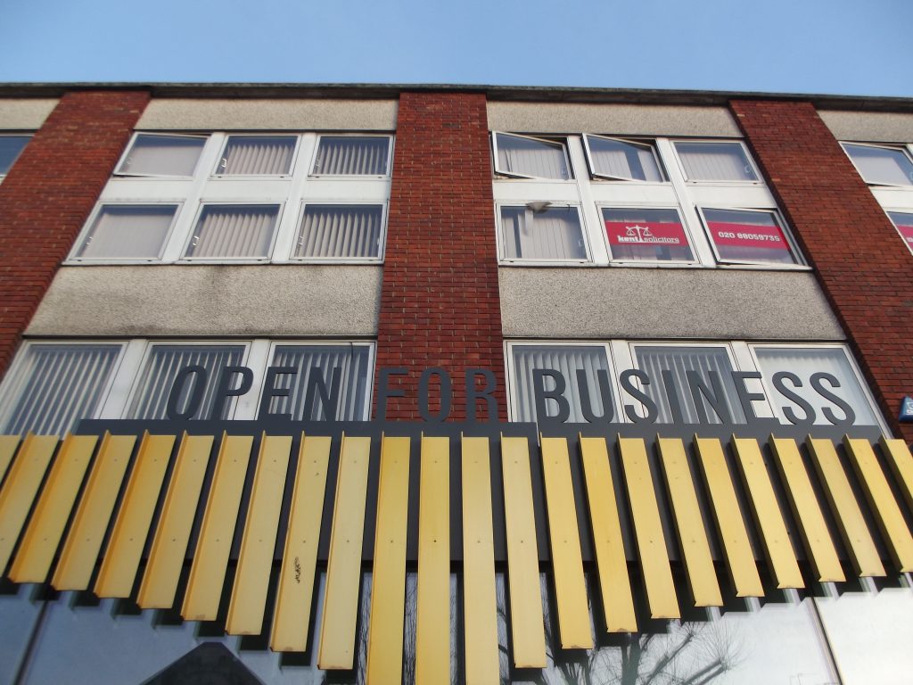 A photo of a business with a sign that says 'Open For Business'